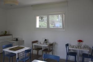 una sala da pranzo con due tavoli, sedie e una finestra di Tennis Rocchette Resort a Casa Mora