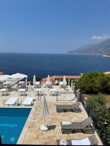 a pool with chairs and umbrellas next to the ocean at Sole'n Blu in Kaş