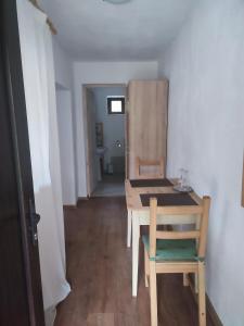 a room with a wooden table and a chair at Dumbrava Minunată in Peşteana