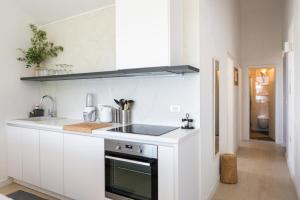 a white kitchen with a sink and a stove at Rural house Pikola with sea view on Vis Island in Komiža