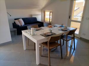 - une table et des chaises blanches dans le salon dans l'établissement Tenuta Marina B&B, à Torino di Sangro