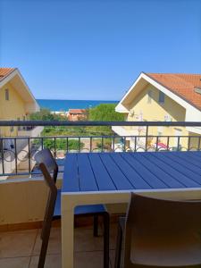 - une table bleue sur un balcon avec vue sur l'océan dans l'établissement Tenuta Marina B&B, à Torino di Sangro