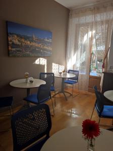 un comedor con mesas y sillas y una pintura en la pared en La Petite Maison, en Florencia