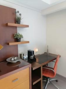 a small kitchen with a desk and a chair at Del Mar Inn Rosarito in Rosarito