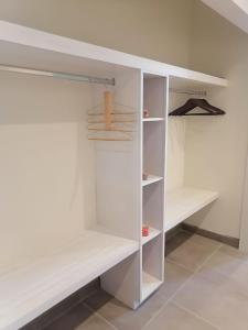 a white walk in closet with white shelves at Del Mar Inn Rosarito in Rosarito