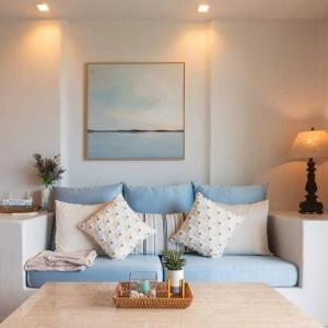 sala de estar con sofá azul y almohadas en Chelona Beachfront Huahin en Khao Tao