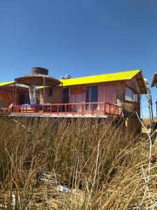 ein Haus mit gelbem Dach am Strand in der Unterkunft Titicaca Kontiki Lodge Peru in Puno