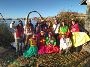 Eine Gruppe von Leuten, die Kostüme tragen, die für ein Bild posieren in der Unterkunft Titicaca Kontiki Lodge Peru in Puno