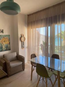 a living room with a glass table and chairs at FRANKI SIVIRI BEACH VIEW in Siviri