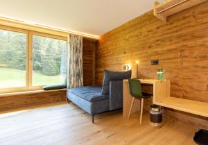 Habitación con sofá azul, escritorio y ventana. en Kessler's Kulm en Davos
