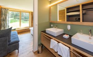 a bathroom with two sinks and a mirror at Kessler's Kulm in Davos