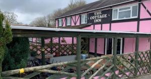 a pink house with a sign that reads the coffee inn at The Cottage Inn in Llandeilo