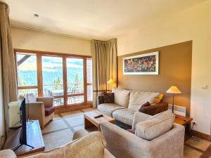 ein Wohnzimmer mit Sofa und Fernseher in der Unterkunft Appartement spacieux avec accès direct aux pistes, piscine, spa et WIFI – Flaine Montsoleil - FR-1-425-120 in Flaine