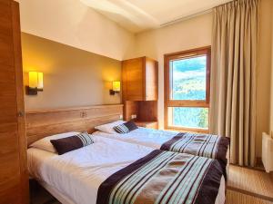 ein Hotelzimmer mit zwei Betten und einem Fenster in der Unterkunft Appartement spacieux avec accès direct aux pistes, piscine, spa et WIFI – Flaine Montsoleil - FR-1-425-120 in Flaine + 15 Fotos