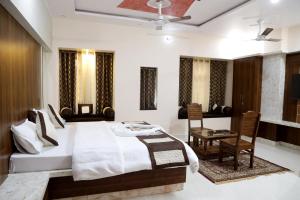 1 dormitorio con 1 cama, mesa y sillas en Hotel Ajeet Palace, en Jaisalmer