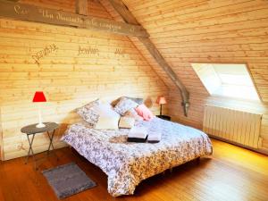 1 dormitorio con 1 cama en una pared de madera en AU COEUR DE LA NATURE, en Allaire