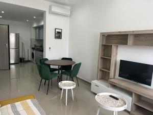 a living room with a table and chairs and a television at Tarrafal Apartments in Tarrafal
