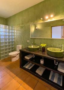 baño con 2 lavabos verdes y aseo en Can Marsá de Baix, en Santa Eulària des Riu