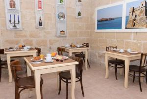 a restaurant with tables and chairs in a room at Casa Ricca in St. Paul's Bay