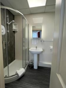 a bathroom with a glass shower and a sink at Rostrevor Hotel - Guest House in Bury