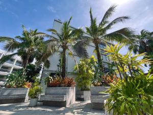 un grupo de palmeras frente a un edificio en Instagramable pool studio 1 bedroom in Bangtao, en Phuket
