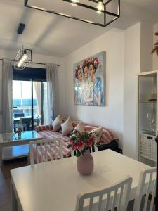 una sala de estar con una mesa con un jarrón de flores. en Apartamento con piscina en el Paseo Cruz del Mar, en Chipiona