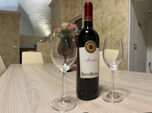 una botella de vino y dos copas de vino en una mesa en JASMINE HOUSE, en Triggiano
