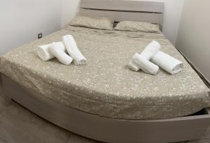 a bed with white pillows and towels on it at JASMINE HOUSE in Triggiano