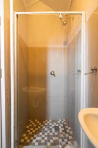 a bathroom with a shower with a checkered floor at Hasate Guest House ,4 st james street Oakdale Belliville Cape Town South Africa in Cape Town