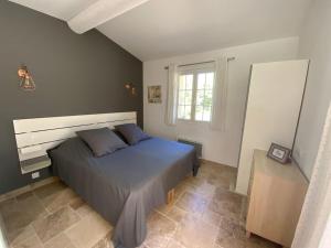 een slaapkamer met een bed en een raam bij Maison au calme au pied du luberon in La Bastide-des-Jourdans