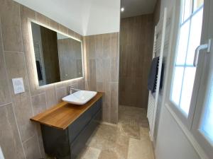 een badkamer met een wastafel en een spiegel bij Maison au calme au pied du luberon in La Bastide-des-Jourdans