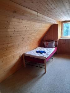 a small room with a bed in a wooden cabin at Haus Guttenberg in Guttenberg
