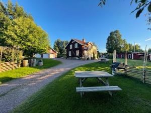 a picnic table on the grass in front of a house at Prinsgården B&B rum stugor in Mora
