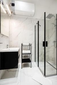 a white bathroom with a shower and a sink at A Golden Star Modern Luxury Apartments and Suites Budapest in Budapest