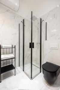 a bathroom with a shower and a black toilet at A Golden Star Modern Luxury Apartments and Suites Budapest in Budapest