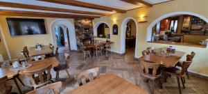 a restaurant with wooden tables and chairs in a room at Restaurant & Pension Liebenstein in Libá