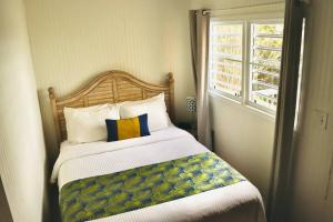 a bedroom with a large bed with a window at The Northside Cottage in St Thomas