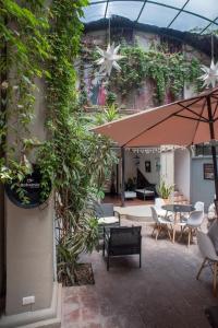 un patio con mesas, sillas y plantas en The Bersal House Flats en San Miguel de Allende