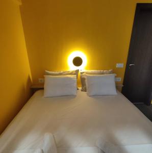 - une chambre avec un grand lit et un mur jaune dans l'établissement PETMEZA APARTMENT 1 by DIMITROPOULOS, à Aigio