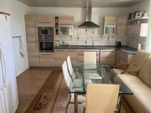 a kitchen with a glass table with chairs and a couch at Halka Apartment 3 in Rabčice +2 photos