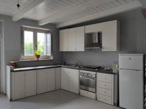 uma cozinha com armários brancos e um frigorífico branco em Fantastica casa ai piedi del Monte Pollino em San Lorenzo Bellizzi
