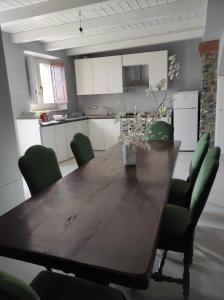 San Lorenzo BellizziにあるFantastica casa ai piedi del Monte Pollinoのキッチン(木製テーブル、緑の椅子付)