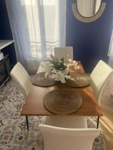 a dining room table with white chairs and a table with flowers on it at L'AMAZONIE - Lovely apartment near to the train station and Orly Airport in Juvisy-sur-Orge +25 photos