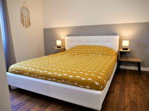 1 cama en una habitación con 2 lámparas en 2 mesas en Appartement moderne entièrement rénové en Aurillac