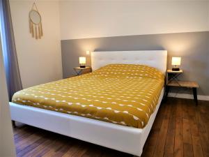 łóżko w pokoju z dwoma lampami na dwóch stołach w obiekcie Appartement moderne entièrement rénové w mieście Aurillac