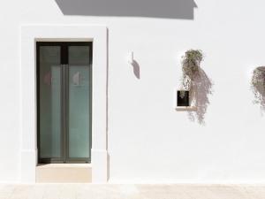 a white building with a glass door on it at Cally Suite Room in Martina Franca