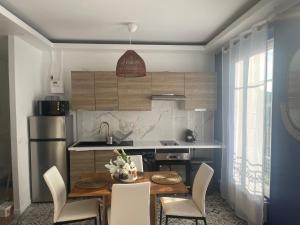 a kitchen with a table and chairs and a kitchen with a refrigerator at L'AMAZONIE - Lovely apartment near to the train station and Orly Airport in Juvisy-sur-Orge