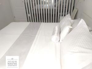 un letto bianco con lenzuola e cuscini bianchi di Luxurios and historic apartment "Shine" - right on the Main Square a Zagabria