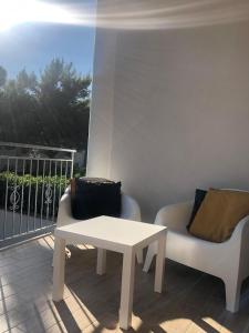 een woonkamer met een tafel en 2 stoelen op een balkon bij B&B Il Castello in Sangineto