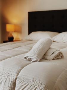 two beds with white sheets and towels on them at La casona Talpen in Constitución